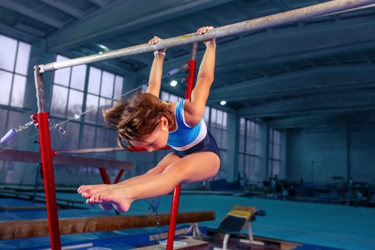 young girl practices gymnastics on a bar