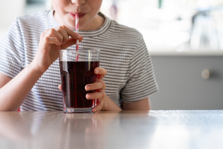 child drinking soda at table