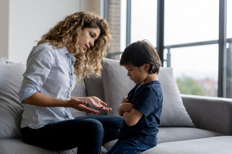 kid sits with crossed arms while talking to mom about emotions