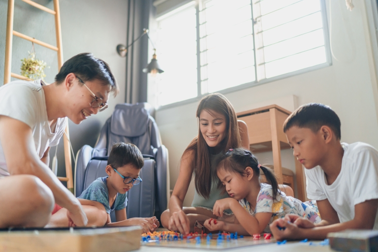 family plays board game in their home