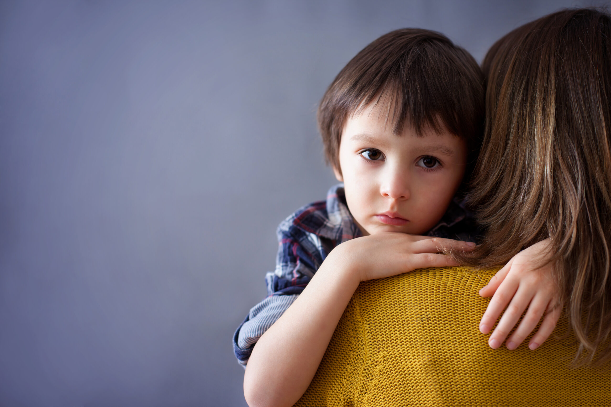 Sad little boy hugs his mother while grieving