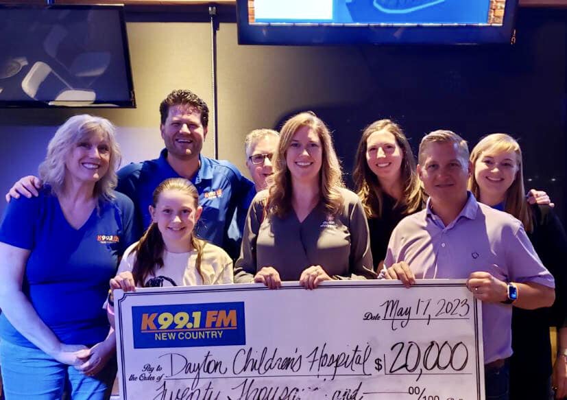 K99.1FM staff pose with the Radiothon donation check for Dayton Children's