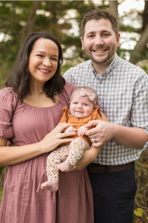 Ben Heil poses for a photo with his wife and daughter