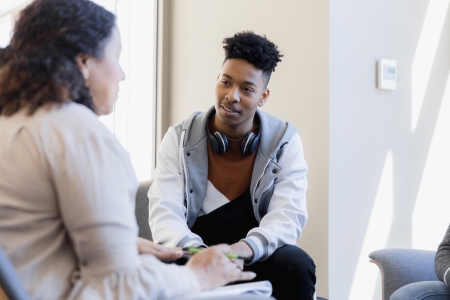 teenager chats with therapist about past experiences