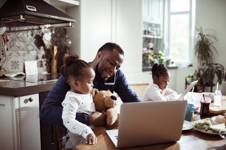 Dad with child on phone and computer