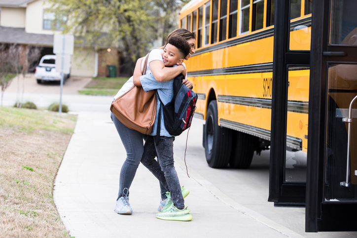 mom says goodbye to son before he gets on the school bus