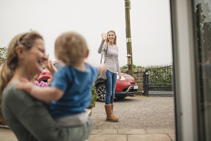 Mom waves goodbye to child at daycare drop off
