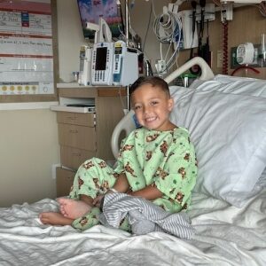 Landon smiles while in a patient bed, being treated for IBD at Dayton Children's.