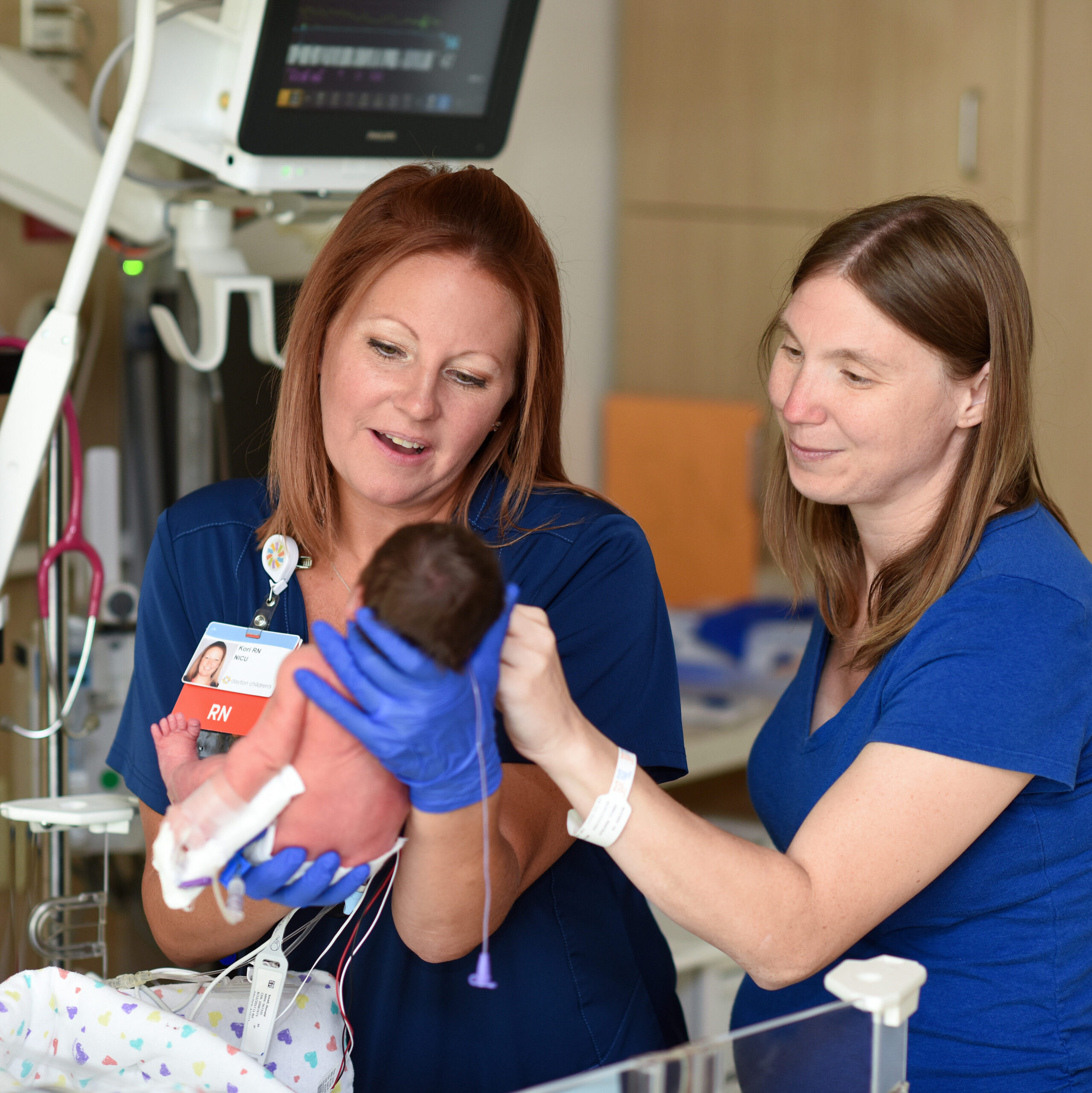 A very young baby in the NICU preparing to be transferred to the TCU by their nurses.