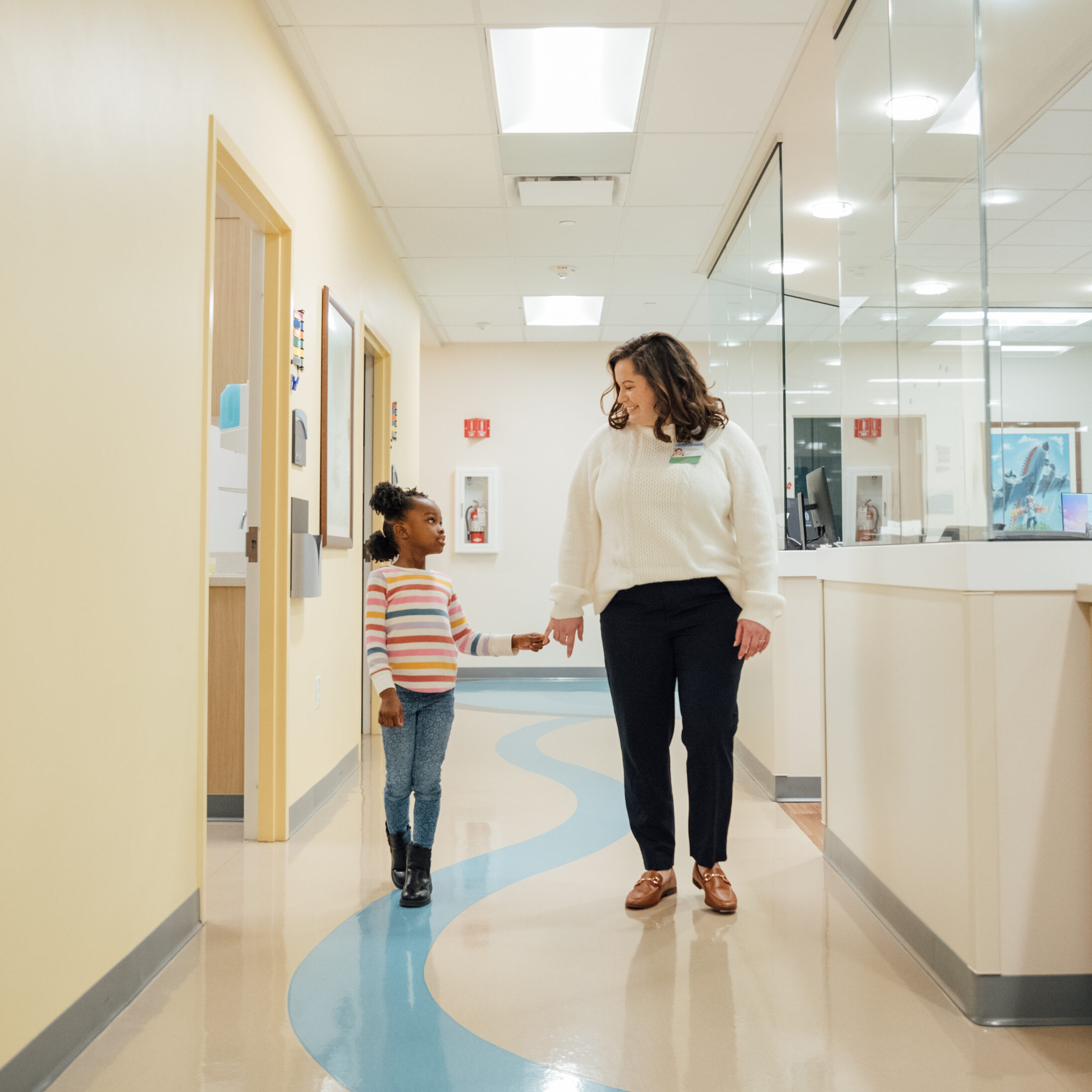 A Nurse Practitioner and patient walk down the hallways of the Developmental Pediatrics department at Dayton Children’s Hospital.