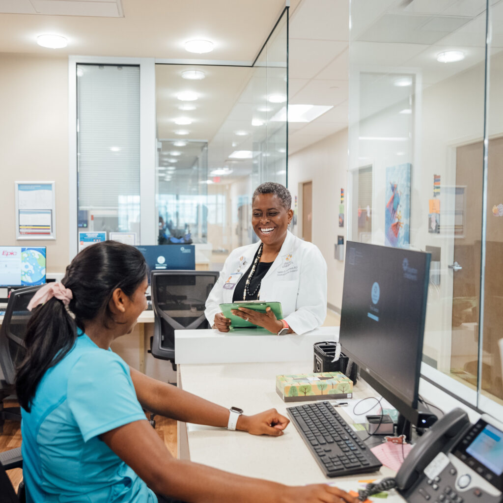 Two staff members discuss a recent patient and figure out if they are meeting the goals for their age group. 