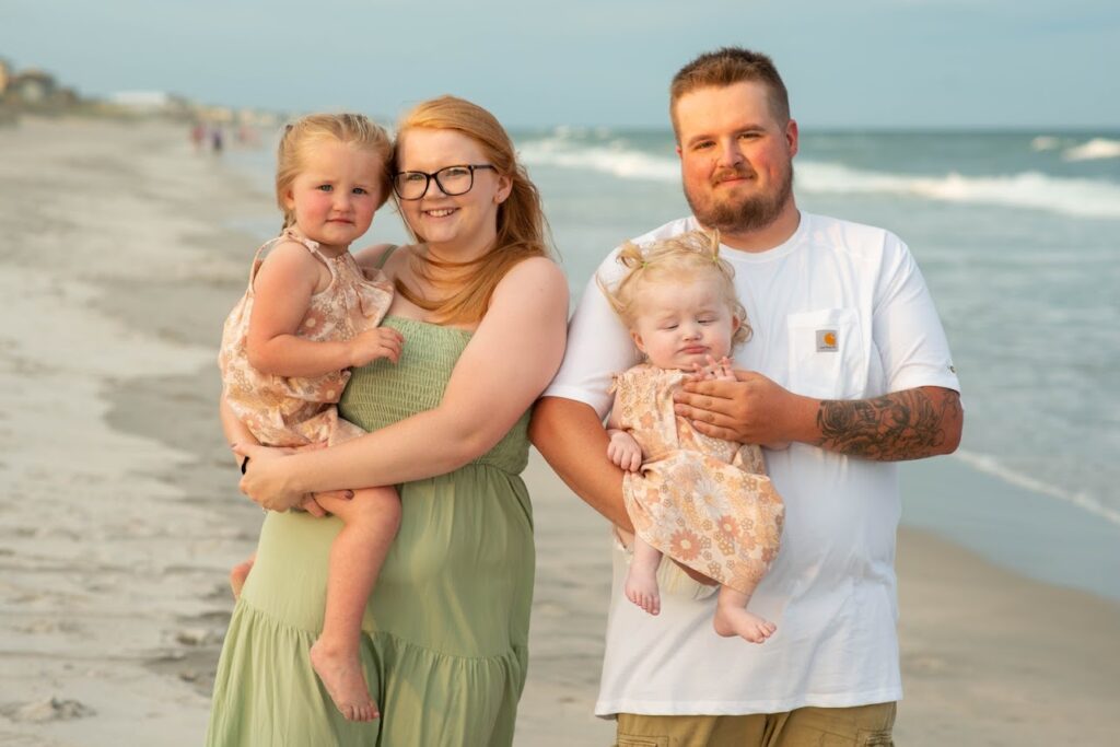 Everleigh's family poses for a photo on the beach