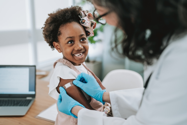 a young girl smiles after getting her flu shot
