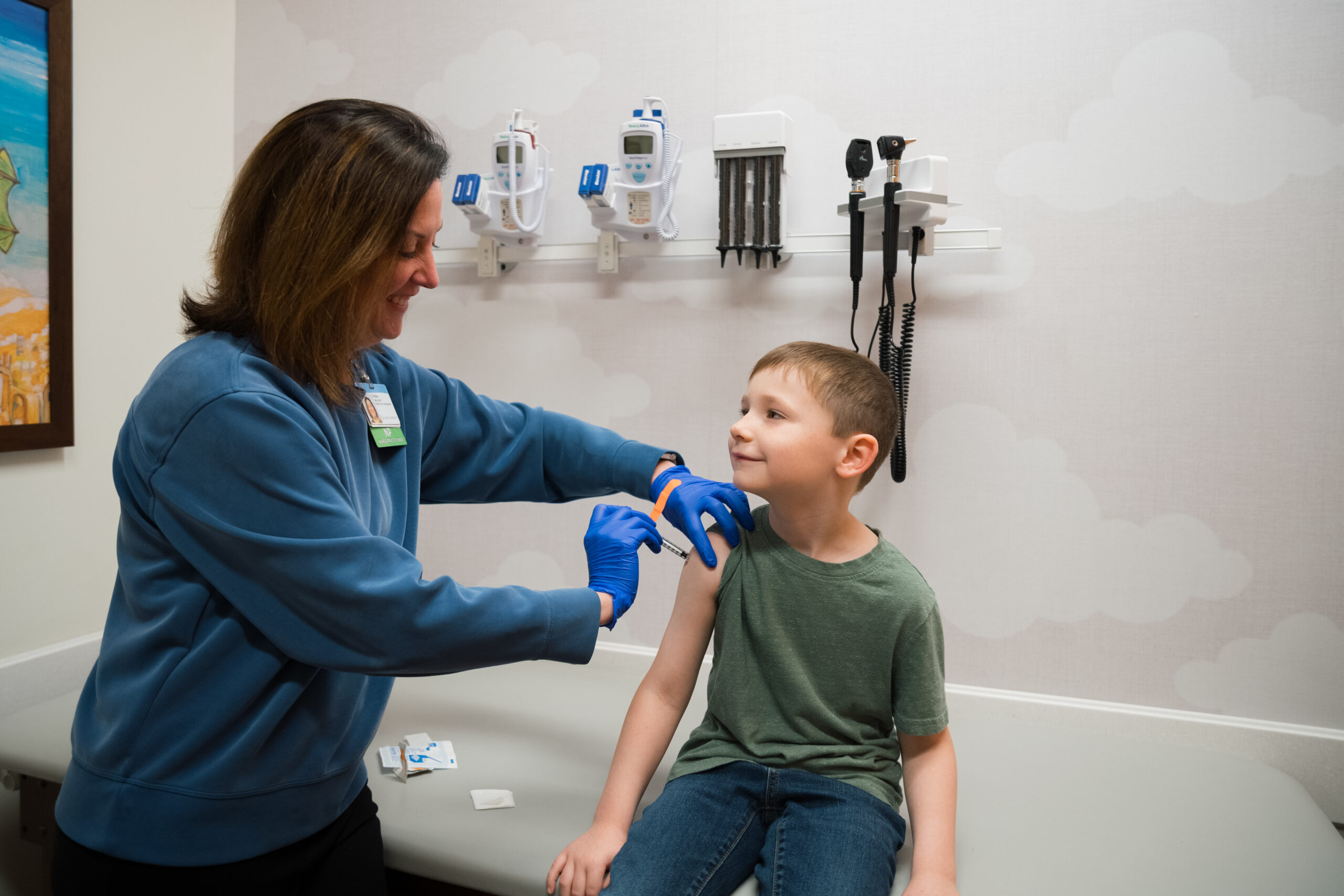 a young boy smiles while getting a flu shot at Kids Express