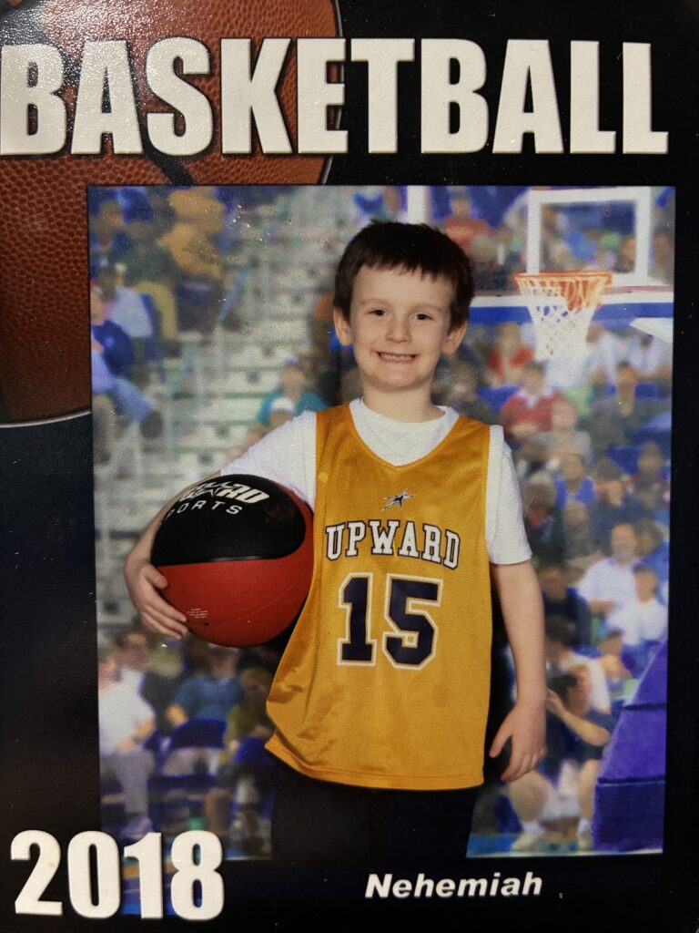 Nehemiah poses for a basketball portrait as a young boy