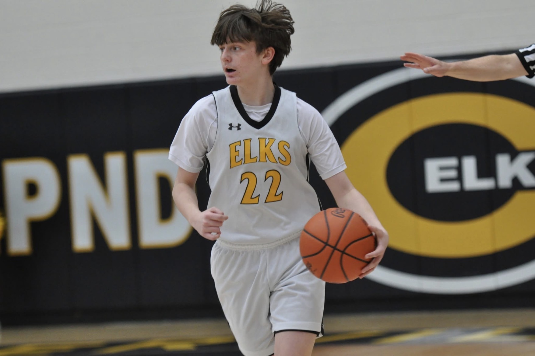 Nehemiah dribbles the ball down the court for the Elks basketball team